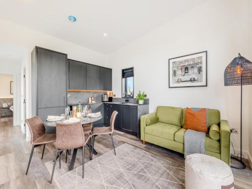 a living room with a green couch and a table at Seiriol Lodge 4 - Uk42794 in Llangefni