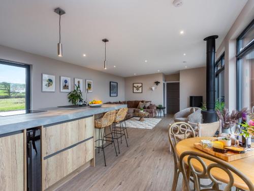 an open kitchen and living room with a bar and chairs at The Granary - Uk48622 in Buchlyvie