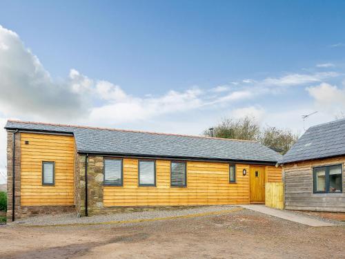 a wooden house with a driveway in front of it at Tyr Ywen Cottage in Abergavenny