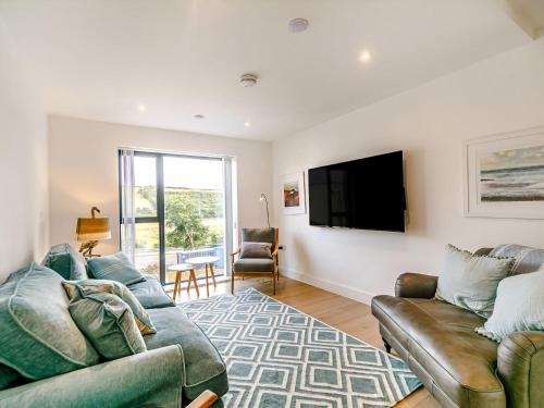 a living room with a couch and a flat screen tv at Puckoo's Nest in Newquay
