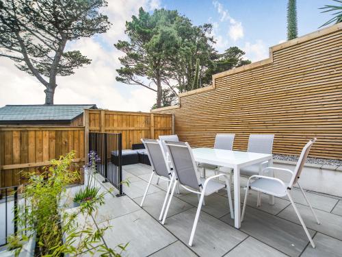 a white table and chairs on a patio at Puckoo's Nest in Newquay