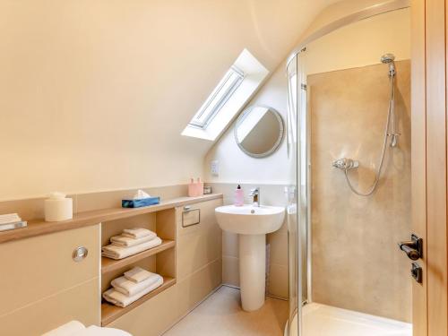 a bathroom with a shower and a sink and a mirror at Rose Cottage - Uk39245 in Inverness