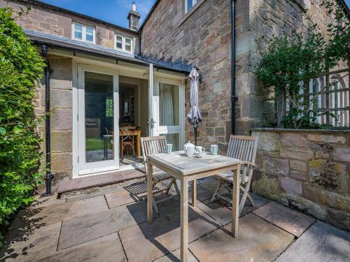 a wooden table and two chairs on a patio at Shellrigg - Uk49891 in Preston