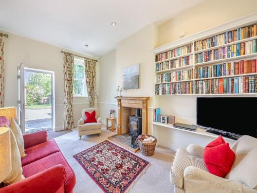 a living room with a tv and bookshelves at Shellrigg - Uk49891 in Preston