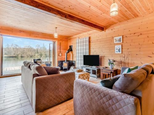 a living room with two couches and a television at Malibu Lakehouse in Pentney