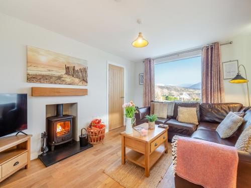 a living room with a couch and a fireplace at Swyn Y Don in Llanfair