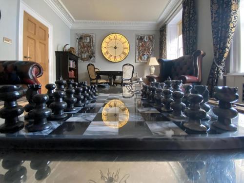 a large chess board in a living room with a clock at Clan Young Suite in Berwick-Upon-Tweed