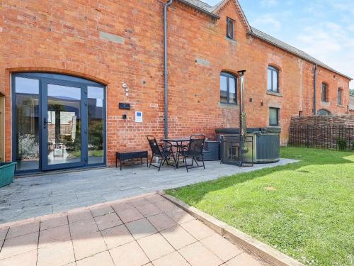 a patio with a table and chairs in front of a brick building at The Cart Arms in Gloucester