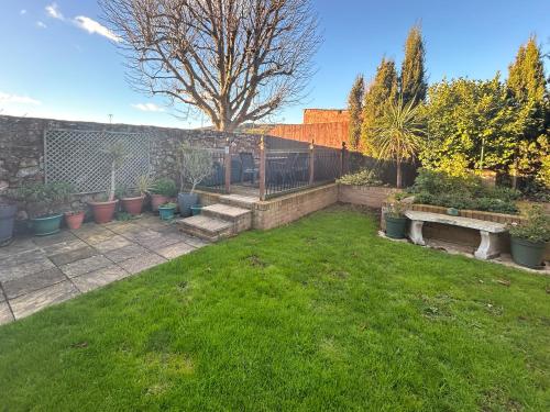 a yard with a fence and a garden with plants at Hill View in Minehead
