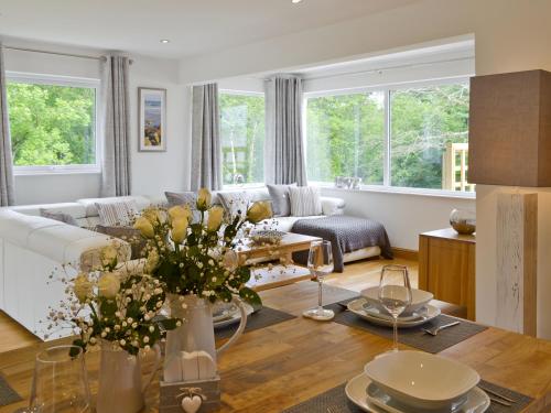 a living room with a couch and a table with flowers at Florina in Cheriton Bishop