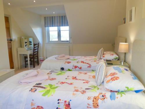a bedroom with two beds with towels on them at The Owl House in Bishops Waltham