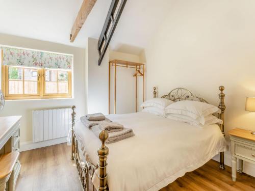 a bedroom with a bed and a desk and a window at Tawny Acre Barn - Uk38614 in Wisbech
