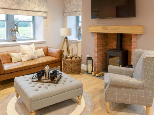 a living room with a couch and a fireplace at Slatehouse Cottage - Uk7562 in Carronbridge