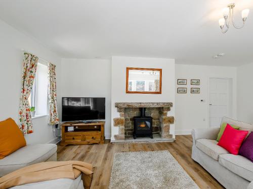 a living room with a couch and a fireplace at Cunliffe Cottage in Hathersage