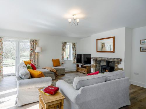 a living room with two couches and a fireplace at Cunliffe Cottage in Hathersage