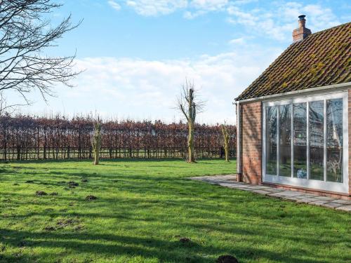a house with a green yard next to a fence at One Chainbridge Barns in Skegness