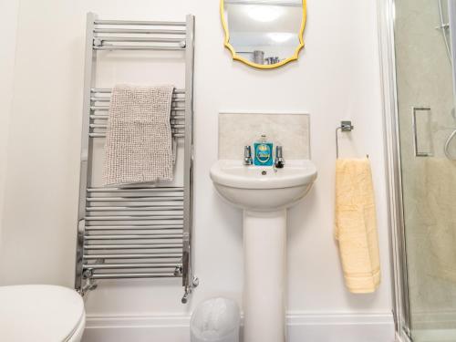 a white bathroom with a sink and a shower at The Gables in Bridlington
