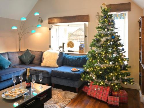 a living room with a christmas tree and a blue couch at Stone Barn - Ukc3594 in Minehead