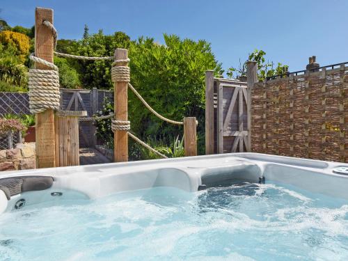 a hot tub in a backyard with a fence at Stone Barn - Ukc3594 in Minehead