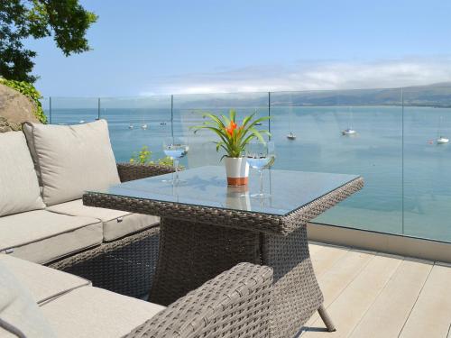 a table and chairs on a patio with a view of the water at Tan Y Fford in Bangor