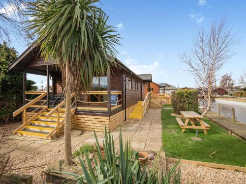 a house with a palm tree in front of it at River Retreat-B6842 in Brundall