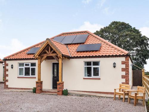 a house with solar panels on the roof at Sycamore Lodge - Uk35106 in Chapel Saint Leonards