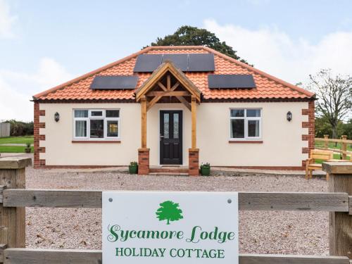 a house with a sign in front of it at Sycamore Lodge - Uk35106 in Chapel Saint Leonards