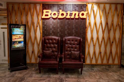 a brown leather chair sitting in front of a store at Hotel Bobina in Gorakhpur