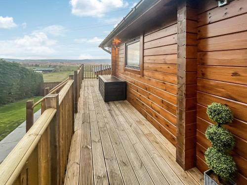 a wooden deck with a bench on the side of a house at Coo Lodge - Uk48430 in Falkirk