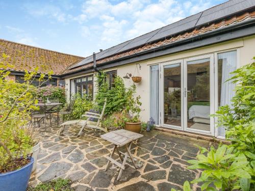 a garden with a patio with chairs and a table at The Granary Store in Woodrising