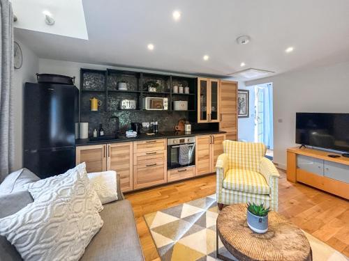 a living room with a couch and a tv at Eagles Nest in Guildford