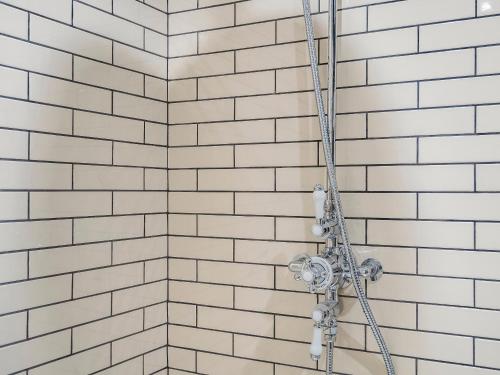 a shower with white subway tiles in a bathroom at The Pavilion in Willoughby