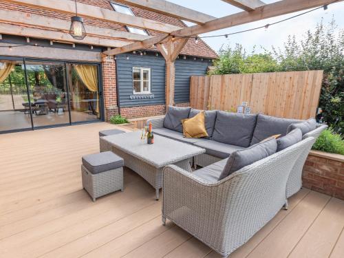 a patio with a couch and a table at Lucky's Stable - Uk34101 in Chichester