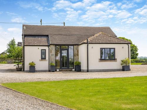 a small white house with grass in front of it at Whitehill Barn - Uk47195 in Kirkcambeck