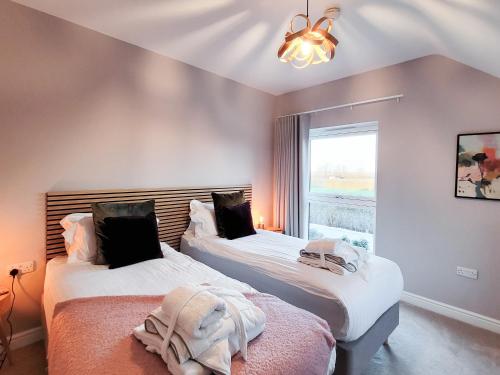 two beds in a room with a window at The Birches - Ukc4619 in Dunholme
