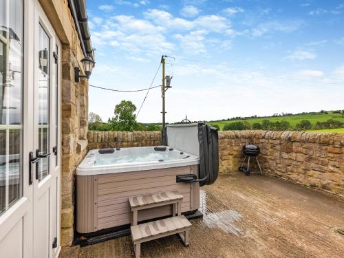 a hot tub sitting on the side of a building at Bolton Farm in Durham