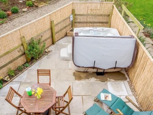 a bath tub sitting on a patio with a table at The Hayloft - Ukc1038 in Hickling