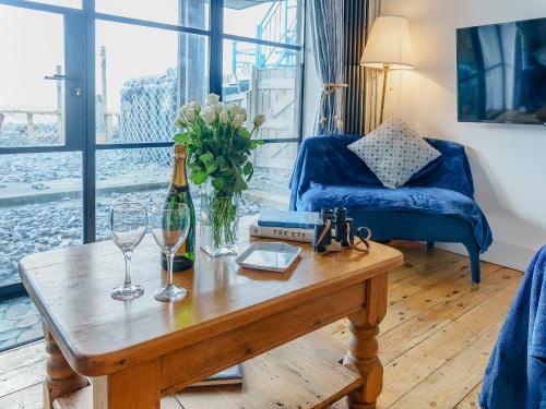a living room with a table with a bottle of wine at Ystwyth House in Borth