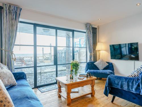 a living room with a blue couch and a table at Ystwyth House in Borth