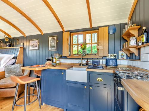 a kitchen with blue cabinets and a sink at Flossys Hut - Uk43675 in Haworth
