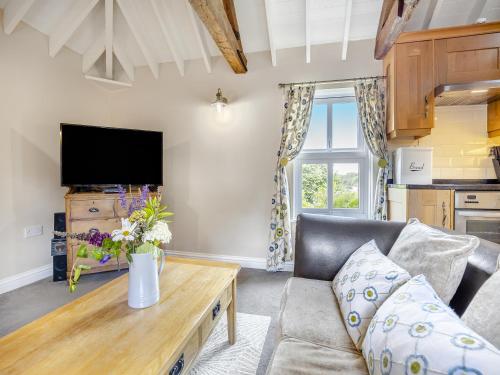 a living room with a couch and a table at The Hayloft - Uk47153 in Burgh le Marsh