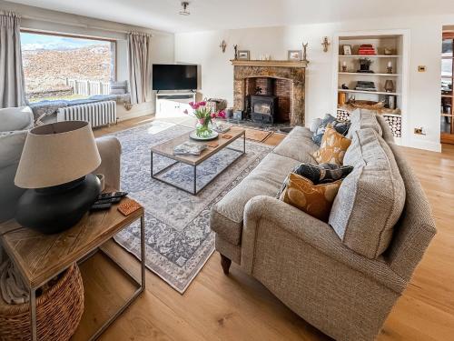 a living room with a couch and a fireplace at Rubha Lodge in Shieldaig