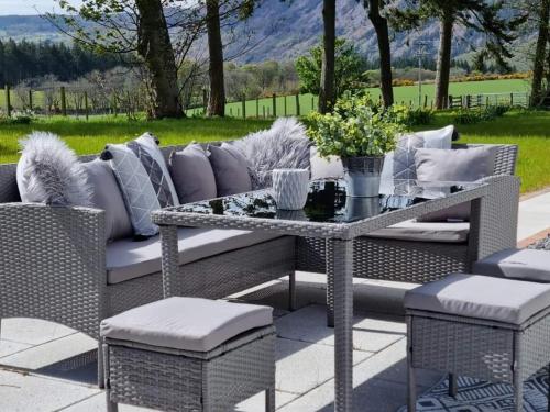 a patio with a couch and a table and chairs at Darris Farmhouse in Lochend