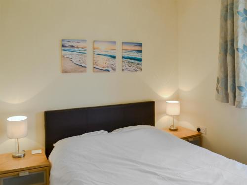 a bedroom with a white bed and two lamps at The Parade Apartment in Reighton