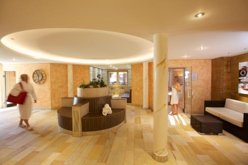 a woman walking through a living room at Naturparkhotel Adler in Wolfach