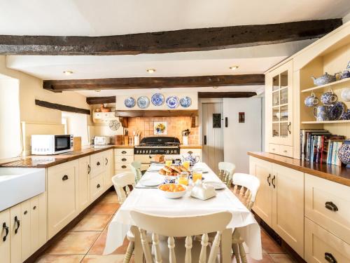 a kitchen with a white table and chairs at Pilgrim Corner in Minehead