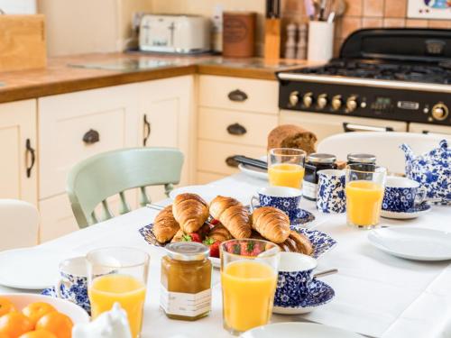 a table with a breakfast of croissants and orange juice at Pilgrim Corner in Minehead