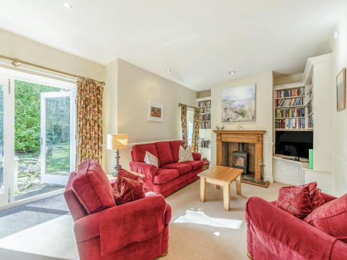 a living room with two red chairs and a fireplace at Longlands - Uk49289 in Preston