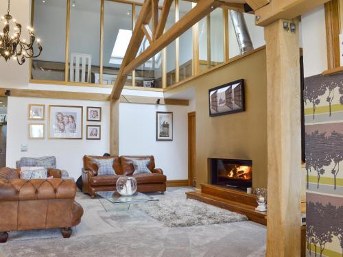 a living room with couches and a fireplace at Carr End Barn A in Preesall
