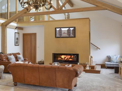 a living room with a couch and a fireplace at Carr End Barn A in Preesall
